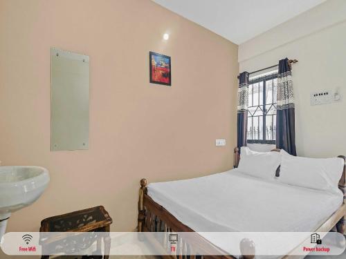 a small bedroom with a bed and a sink at Hotel O On The Rocks in Goa
