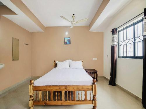 a bedroom with a bed and a window at Hotel O On The Rocks in Goa