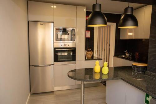 a kitchen with a stainless steel refrigerator and a counter at Apartamento Janelas da Ria in Faro