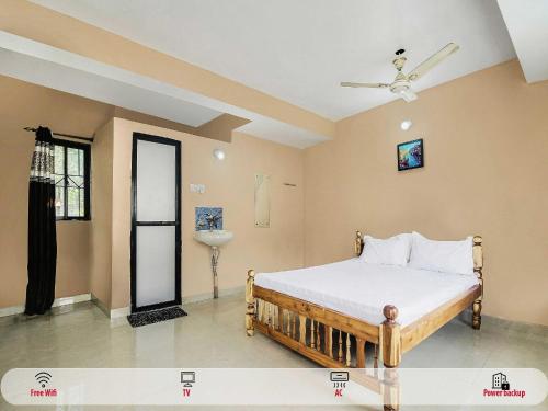 a bedroom with a bed and a ceiling fan at Hotel O On The Rocks in Goa
