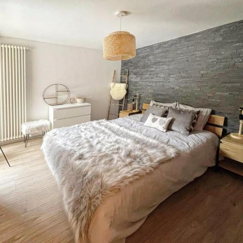 a bedroom with a large bed and a brick wall at L'AvantGardiste, Spacious 6 bedrooms duplex, panoramic view in Crans-Montana