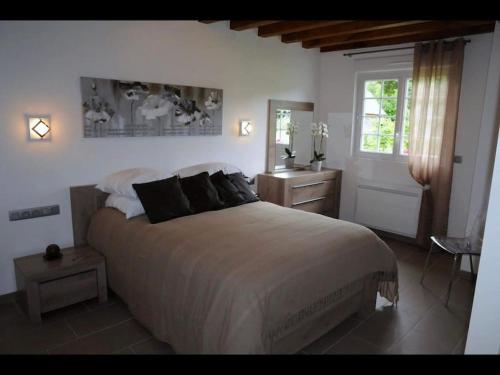 une chambre avec un grand lit et une fenêtre dans l'établissement Le Pressoir de Bigard, à Campigny