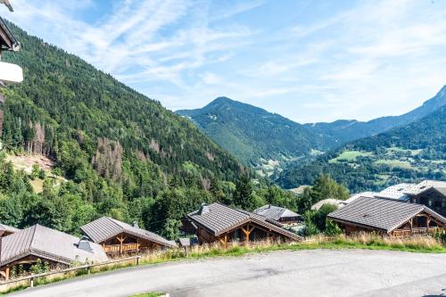 - une vue sur un village de montagne avec des montagnes en arrière-plan dans l'établissement Le Petit Aulps - Studio avec vue montagne, à Saint-Jean-dʼAulps