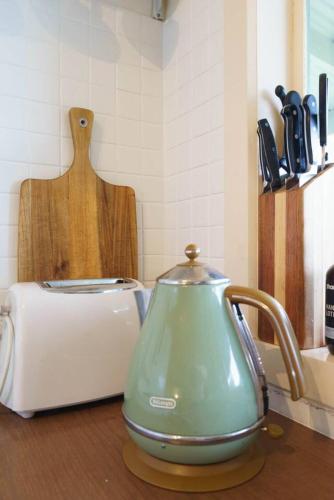 a green tea kettle sitting on a counter next to a toaster at 'Flinders Cabin' A Cosy Family Beach Shack in Flinders