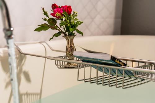 a glass table with a vase with a flower in it at Pinecrest Bed & Breakfast in Asheville