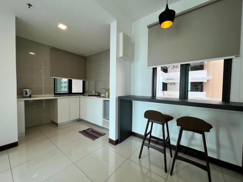 a kitchen with two stools and a counter in it at Private Residence Waterfront in Port Dickson