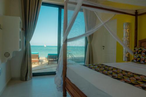 a bedroom with a bed and a view of the ocean at Villa Citrus Zanzibar in Jambiani