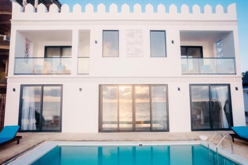 a house with a swimming pool in front of it at Villa Citrus Zanzibar in Jambiani