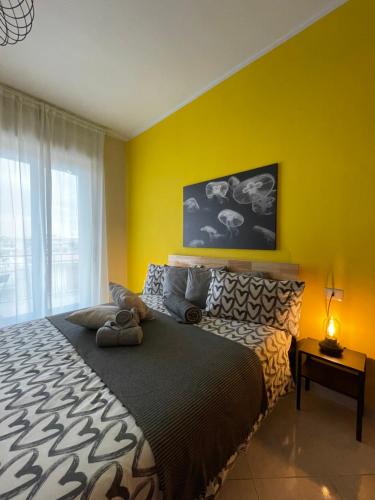 a bedroom with a large bed with a yellow wall at B&B D'Aponte Home in Volla