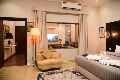 Cet appartement comprend une chambre avec un lit et une chaise ainsi qu'un salon. dans l'établissement Swan Suites, à Lahore