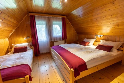 1 dormitorio con 2 camas en una cabaña de madera en Počitniška hiša Taler en Bohinj