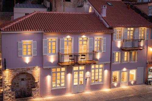 a large white building with windows at night at Navria by Aetoma in Nafplio