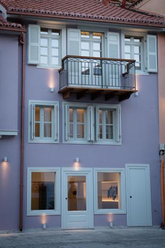 a building with a balcony on the side of it at Navria by Aetoma in Nafplio