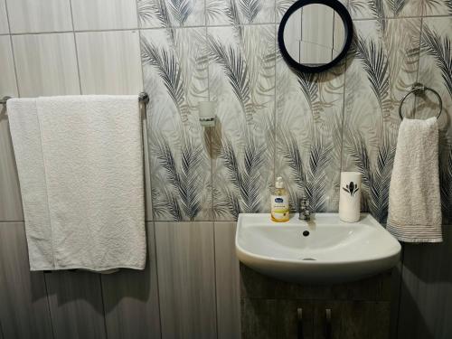 a bathroom with a sink and a mirror and towels at Duvha Guesthouse in Graskop