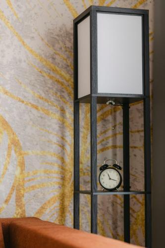 a clock sitting on a table next to a wall at The Forest - Luxe Central Apt with free secured parking in Braşov