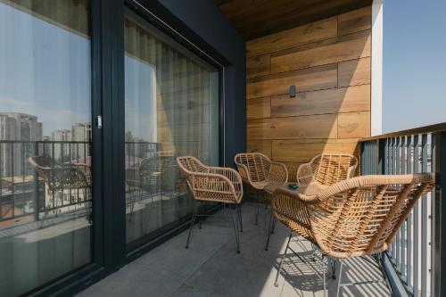a balcony with chairs and a view of the city at The Forest - Luxe Central Apt with free secured parking in Braşov