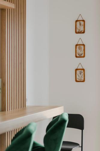 a desk with a chair and two clocks on the wall at The Forest - Luxe Central Apt with free secured parking in Braşov