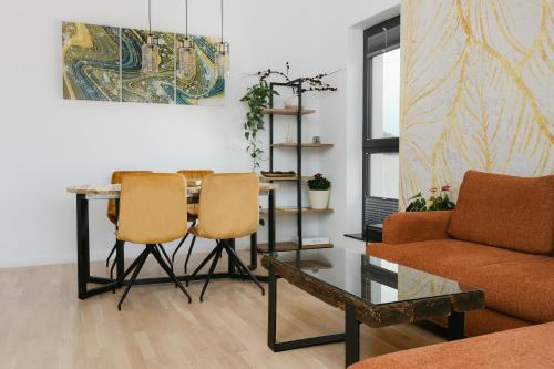 a living room with a table and two chairs at The Forest - Luxe Central Apt with free secured parking in Braşov
