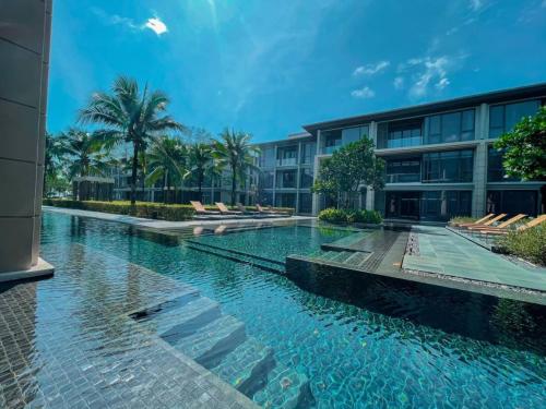 a swimming pool in front of a building at Baan Mai Khao apartments Phuket in Mai Khao Beach