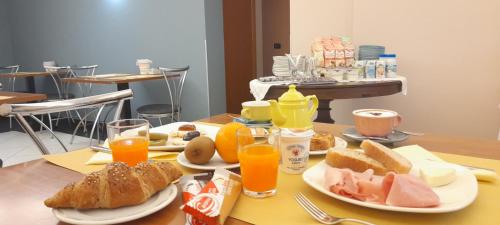 a table topped with plates of food and orange juice at Hotel Ceretto in Busca
