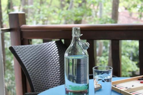 een fles water zittend op een tafel met een glas bij PLATANOFYLLA Studios & Apartments in Kala Nera