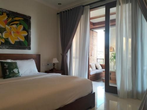 a bedroom with a bed and a sliding glass door at Mandox Villa Bali in Ungasan