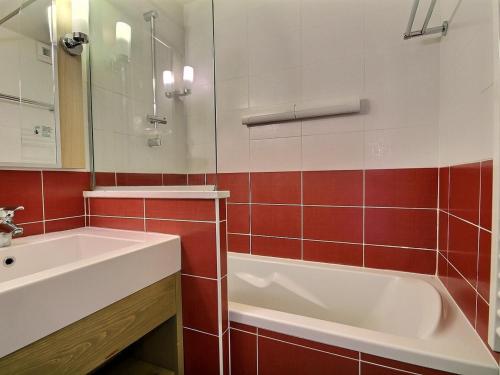 une salle de bain avec un lavabo, une baignoire et un miroir dans l'établissement Grand studio-cabine près des pistes, balcon, vue montagne - FR-1-455-214, à La Plagne Tarentaise