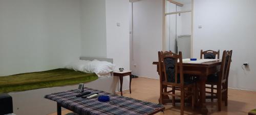 a room with a table and a bed and a table and chairs at Apartman Boba in Ruma