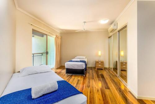 Postcard Perfect - Cairns Nine Pool Tropical Oasis في Westcourt: غرفة فندقية بسريرين ونافذة