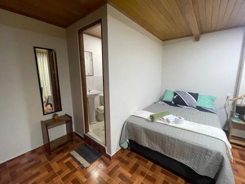um quarto com uma cama e um espelho em Paz y Bien em Villa Rica