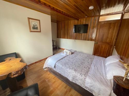 um quarto com uma cama e uma televisão na parede em Paz y Bien em Villa Rica