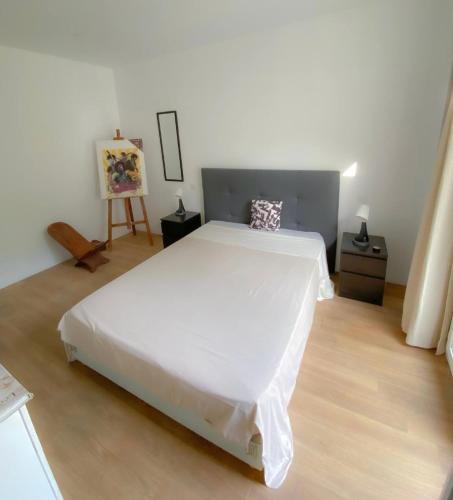 Un dormitorio con una gran cama blanca y una pintura en Villa contemporaine - Prima Volta en Niza