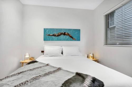 biała sypialnia z łóżkiem z kocem w obiekcie Modern meets Tropical in this Free-standing Home w mieście Cairns North
