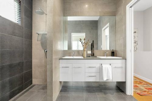 łazienka z 2 umywalkami i prysznicem w obiekcie Modern meets Tropical in this Free-standing Home w mieście Cairns North