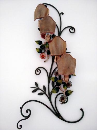 a metal vine with flowers on a wall at Avocado B&B Beyond in Giardini Naxos