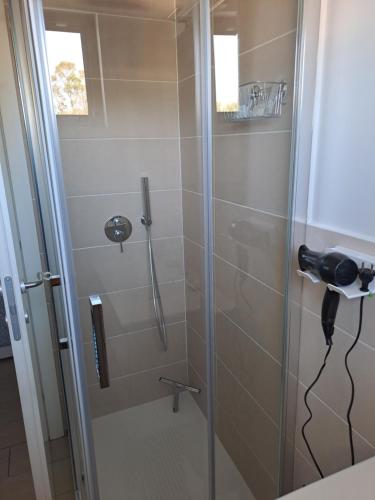um chuveiro com porta de vidro em um banheiro em Fiumicino Airport Sunflower Room em Fiumicino