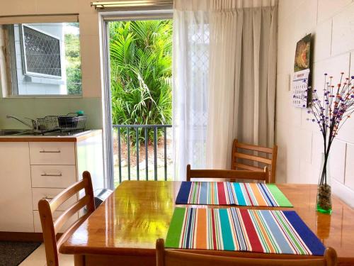 una cucina con tavolo in legno, sedie e finestra di Coastal Living near Shops and Botanical Gardens a Edge Hill