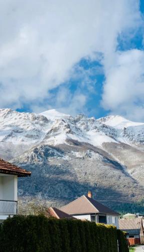 a snow covered mountain in the distance with houses at Lejla's guesthouse in Gusinje