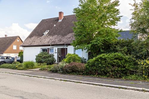 una casa bianca con un tetto nero su una strada di Eule a Donaueschingen