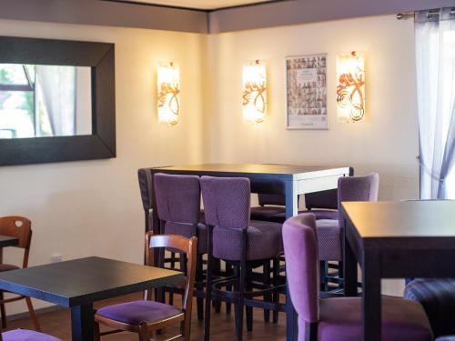 a dining room with purple chairs and tables at Campanile Hotel Runcorn in Runcorn