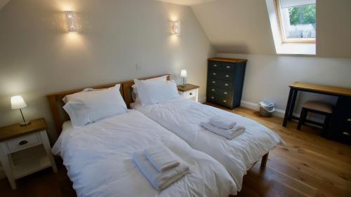 a bedroom with two beds with towels on them at Edinample Lodge in Lochearnhead
