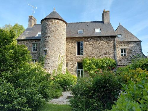 uma velha casa de tijolos com uma chaminé por cima. em Manoir de l'Angélus em Dol-de-Bretagne
