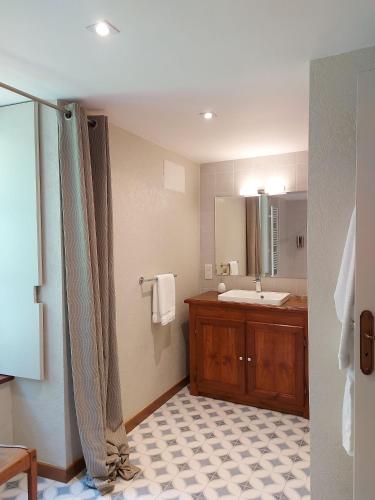 une salle de bain avec un lavabo et un miroir dans l'établissement Manoir de l'Angélus, à Dol-de-Bretagne