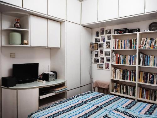 um quarto com uma secretária, um computador e livros em Books&Bed Close to the Lake em Hangzhou