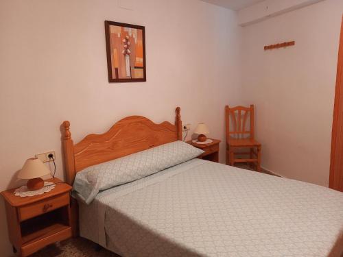 1 dormitorio con 1 cama, 2 mesas y 2 sillas en Casa Esteban, en Vilanova de la Reina (Villanueva de Viver)