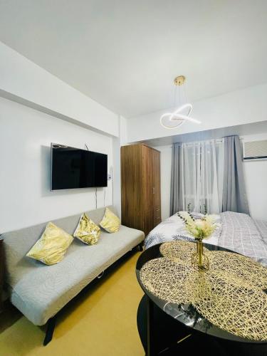 a room with a bed and a table and a couch at City View Studio Unit at Centrio Tower beside Ayala Mall in Cagayan de Oro