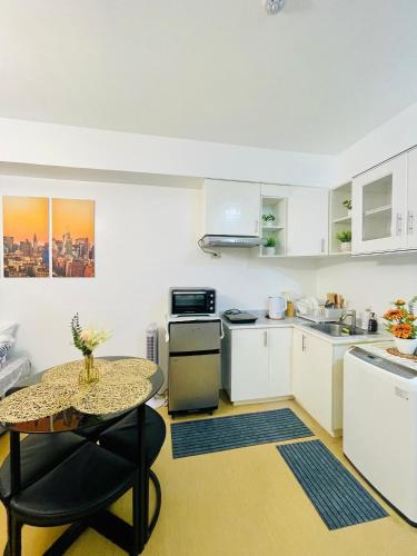 a kitchen with a table and a small table with a table at City View Studio Unit at Centrio Tower beside Ayala Mall in Cagayan de Oro
