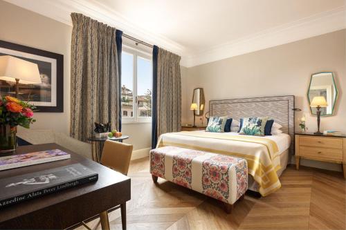 a hotel room with a bed and a table and a desk at Rocco Forte Hotel De Russie in Rome