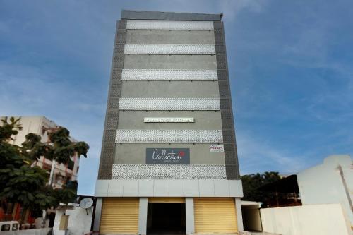 un edificio alto con un cartel en el costado en Super Capital O 65104 Che Sigma Hotel, en Surūrnagar