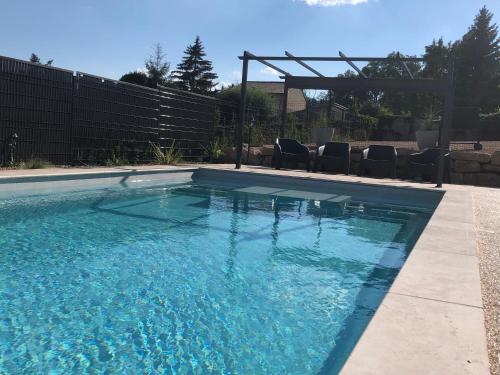 Una piscina con agua azul en un patio. en Gîte Raisin Rose, en Émeringes